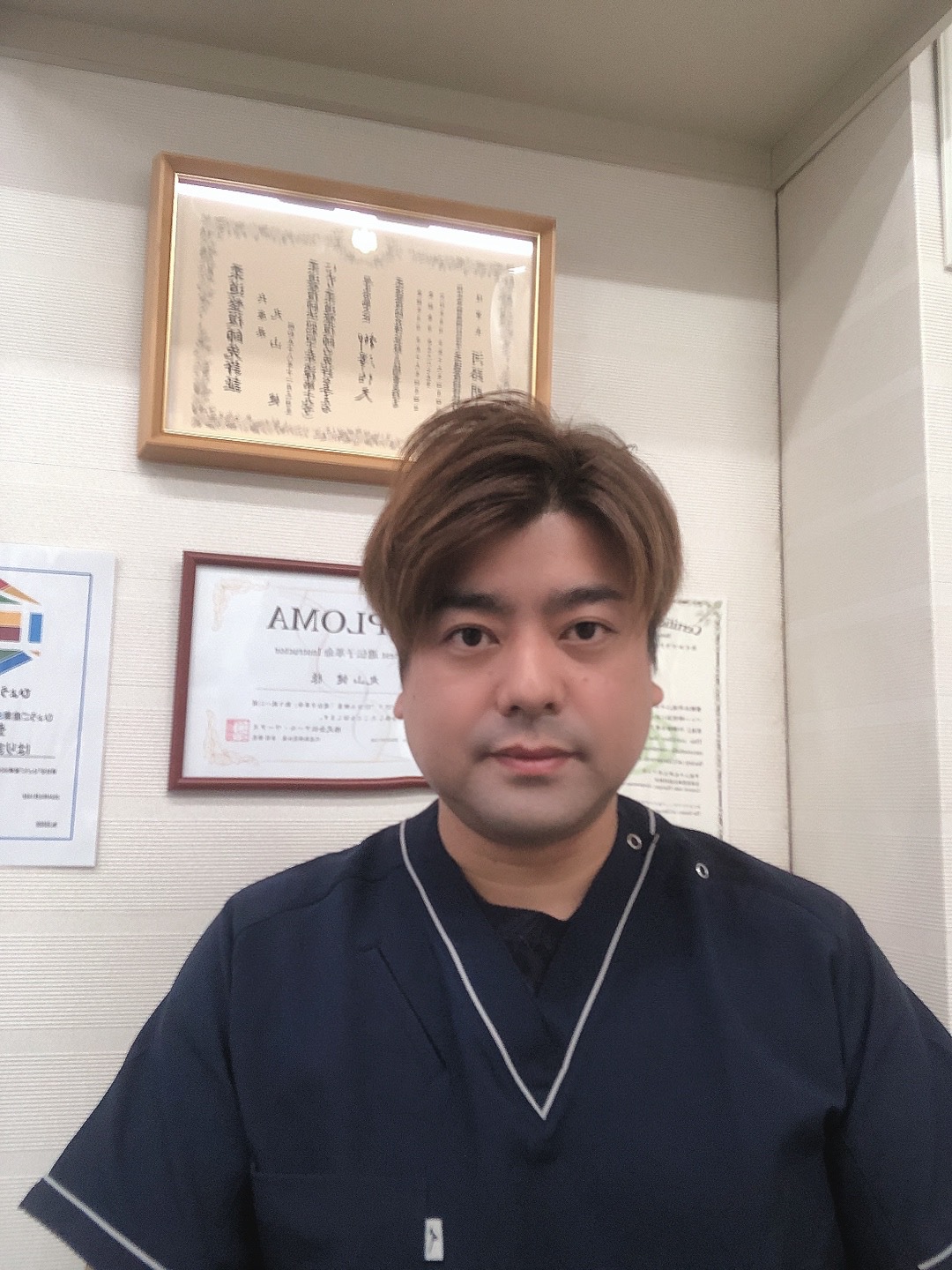 院長・丸山氏が証書の前で撮影したプロフィール写真